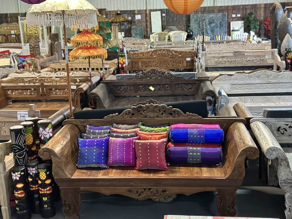 wooden carved daybed with colourful decorative pillows